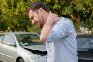 Man with neck pain from car accident and needs Chiropractic Adjustment Crown Point.